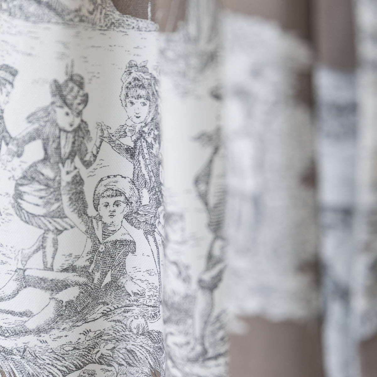Baumwoll-Dirndlschürze Sarah in Taupe mit opulentem Toile de Jouy Muster, Detailansicht Stoff