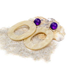 Laden Sie das Bild in den Galerie-Viewer, Diese Statement-Ohrringe vereinen natürliche Eleganz mit mutiger Farbgebung. Der große, ovale Anhänger in edler Hornoptik harmoniert perfekt mit dem runden, glänzenden Cabochon in kräftigem Lila – ein echtes Highlight für alle, die besondere Akzente setzen möchten.