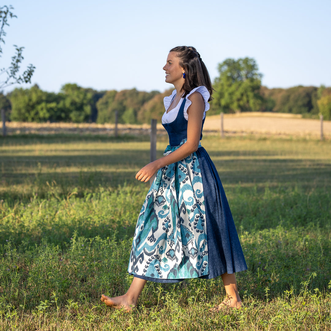 Seitliche Ansicht, Dirndlschürze Carlotta in Blau tönen kombiniert mit dem Dirndl Josefine in dunkellau mit Leinendirndl