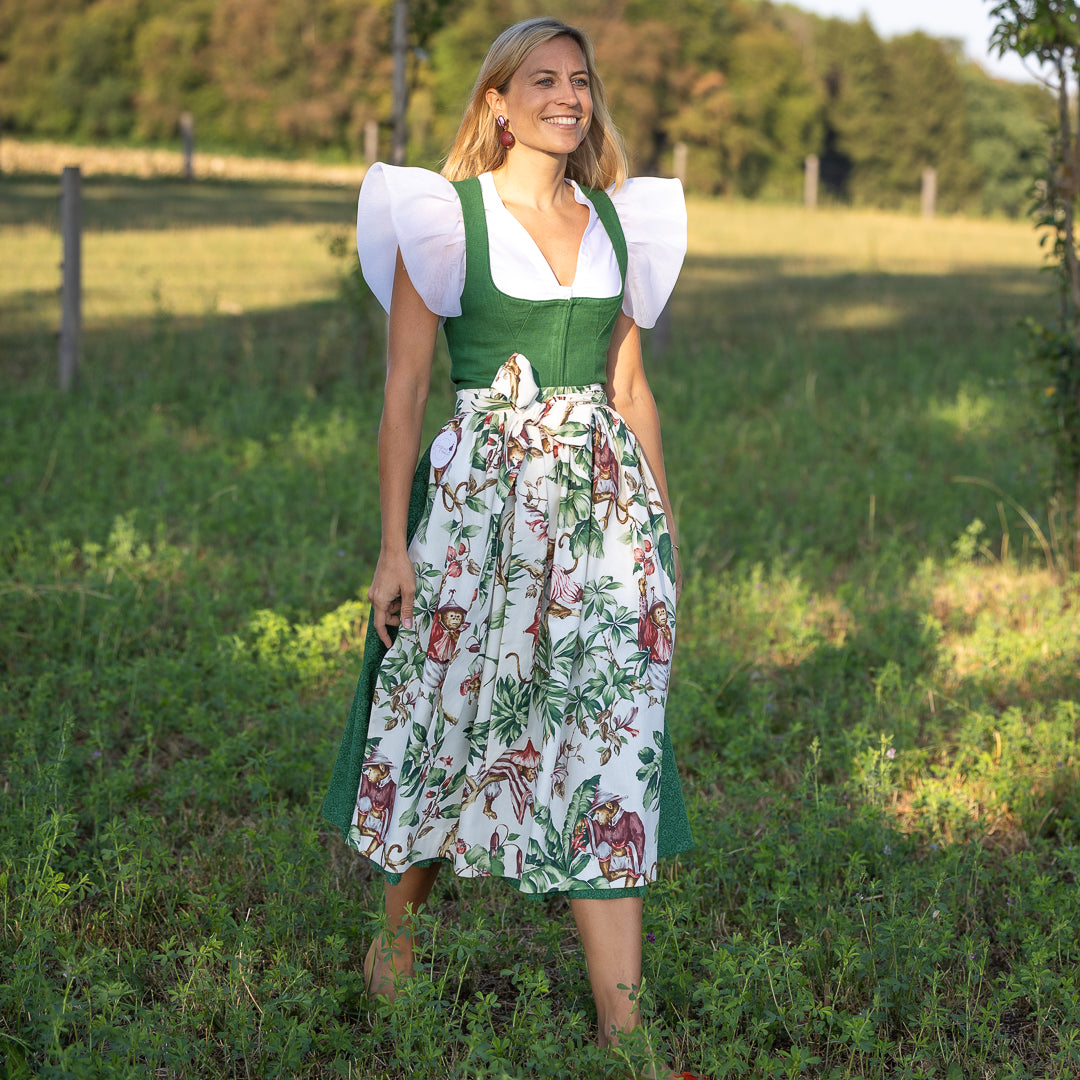 Seitliche Ansicht, Dirndl Josefine in Grün mit Dirndlschürze Henrietta mit Äffchenmotiv